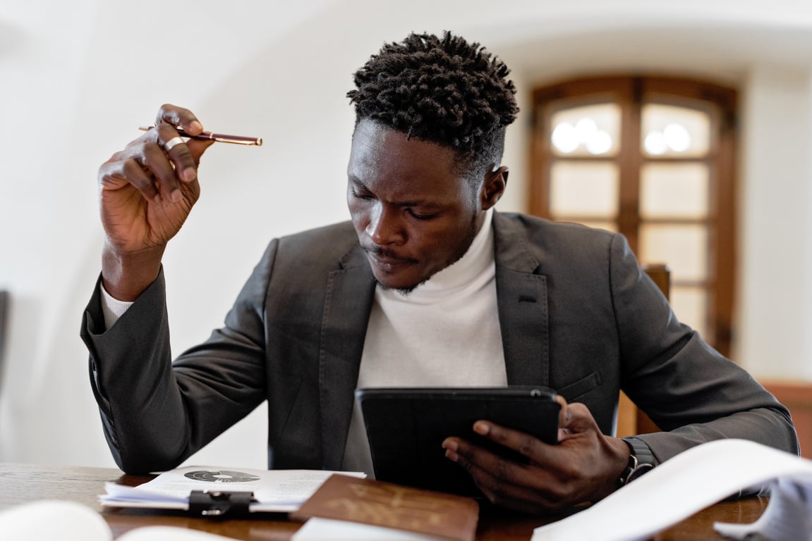 Man in Black Suit Holding Black Tablet Computer