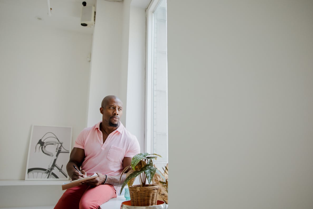 A Man in Pink Polo Shirt Sitting Beside Glass Window